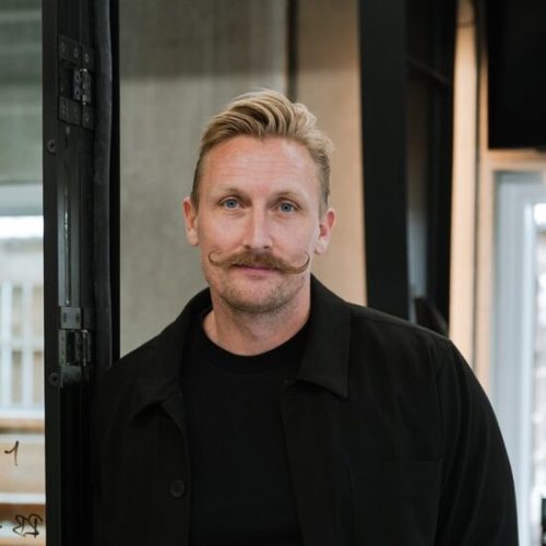 Portrait of a Daniel Ravnholt standing in a modern office environment